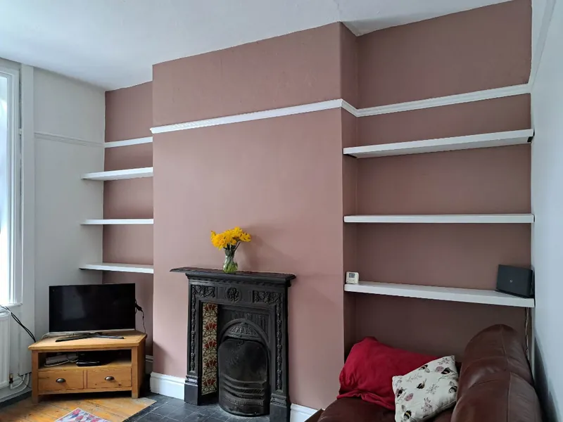 Living room with alcove shelves and chimney breast in dusky pink