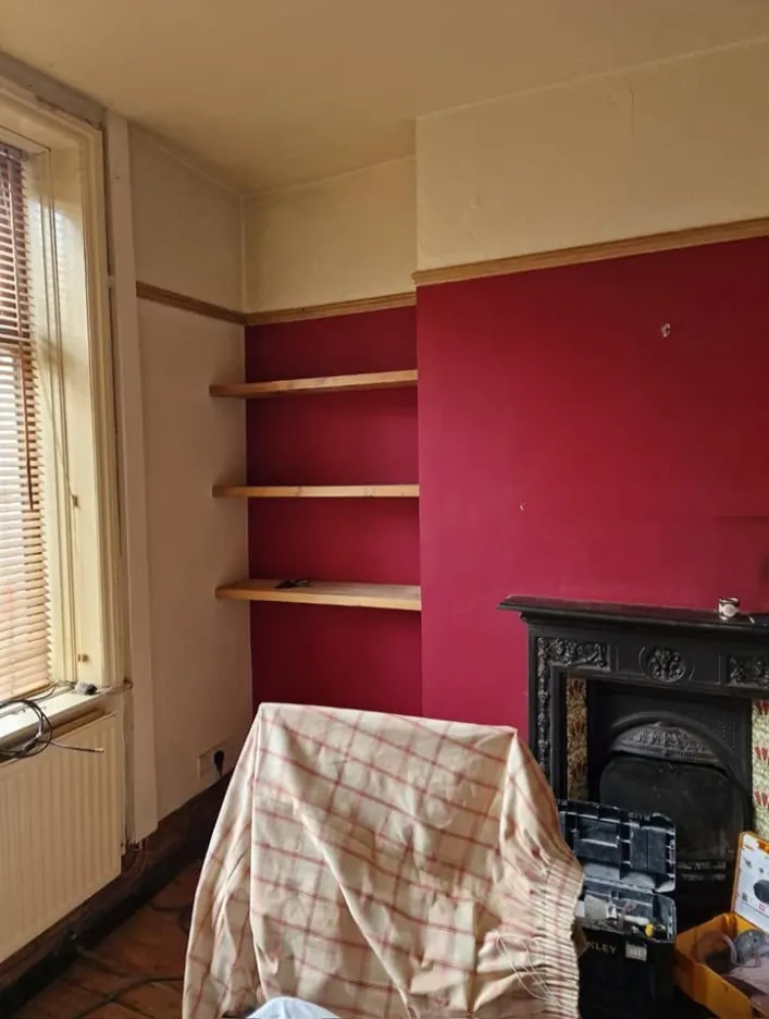 The same room before, with red walls and pine shelves