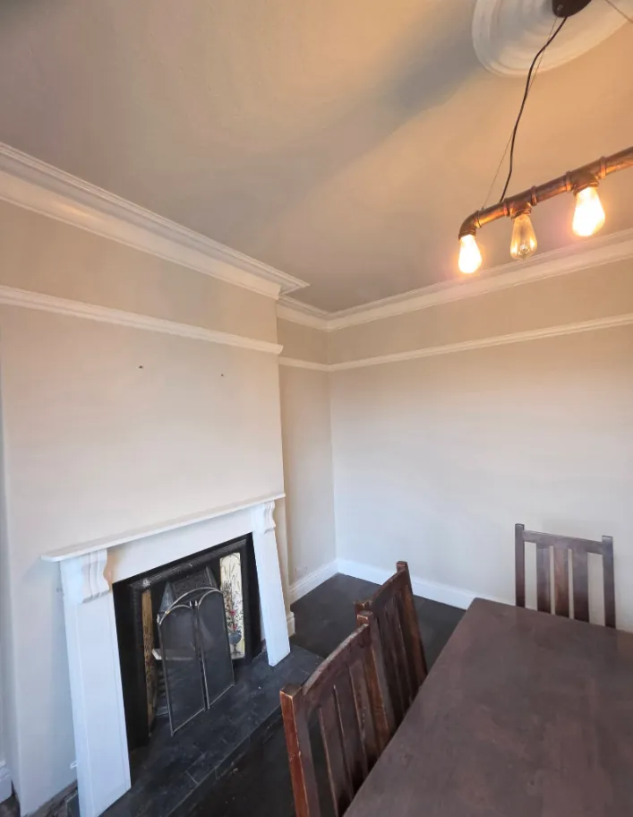 Dining room finished in soft cream around a cast iron fireplace