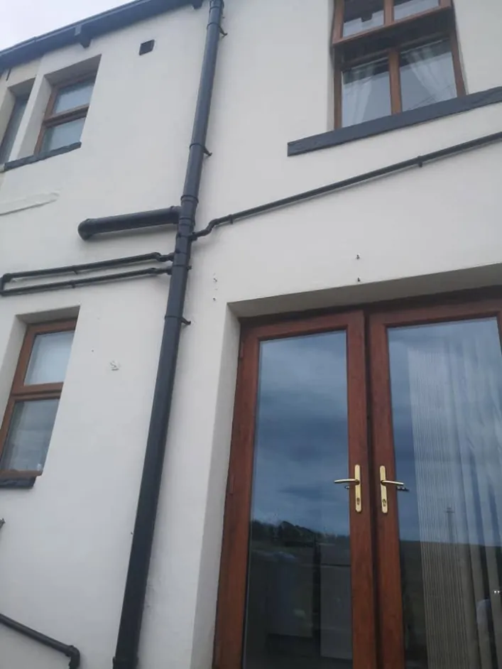 Upper wall of a house freshly finished in white masonry paint
