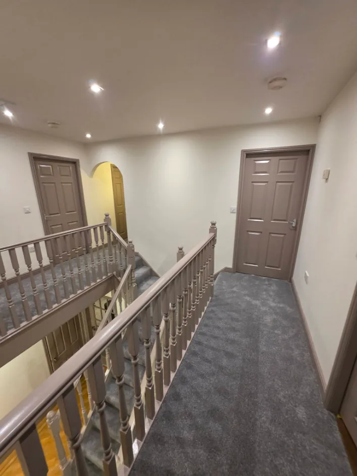 Landing with six panel doors painted taupe and cream walls