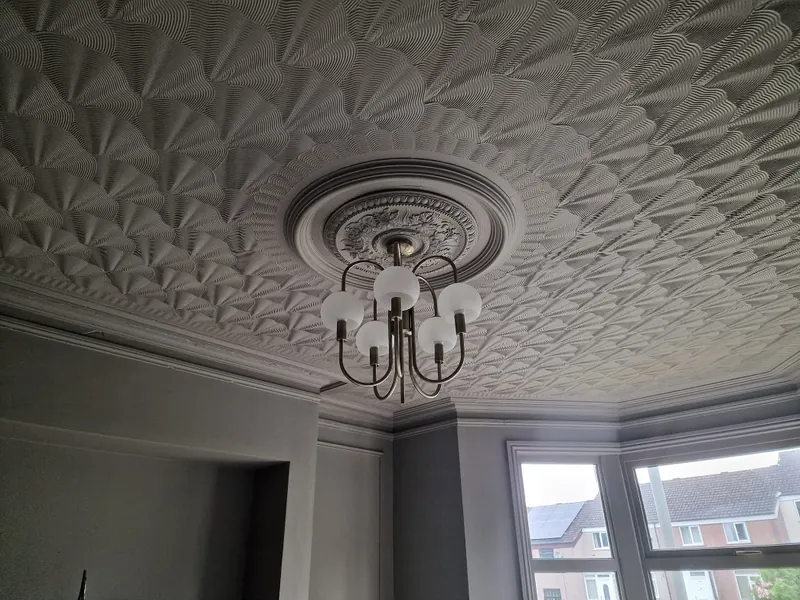 Ornate textured ceiling and ceiling rose painted above dove grey walls
