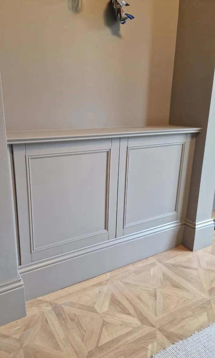 Panelled cabinet and skirting painted in a warm grey over a parquet floor