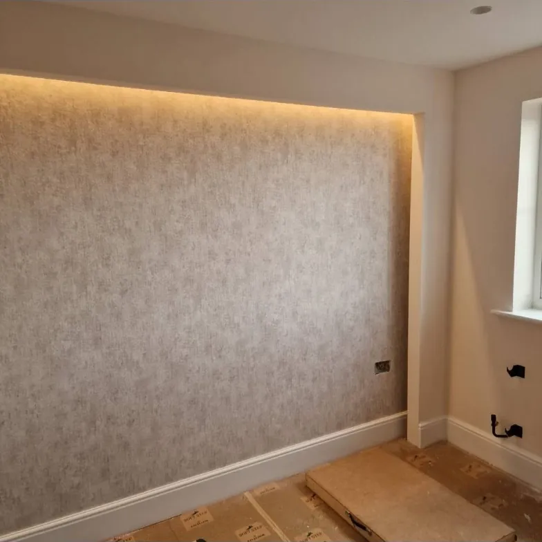 Textured wallpaper feature wall in a lit recess with crisp white woodwork