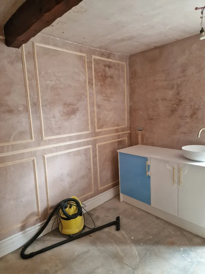 The same room before, bare plaster with new panel mouldings fitted